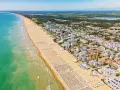 Słoneczna bibione plaża tętni życiem. Tysiące leżaków i parasoli tworzy barwny dywan, a turkusowe morze zaprasza do kąpieli.