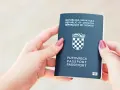Dłonie trzymają chorwacki paszport. Czy do Chorwacji potrzebny jest paszport? Tak, jeśli nie jesteś obywatelem UE.