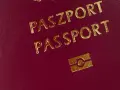 Ciemnoczerwony paszport z napisem "PASZPORT" i symbolem. Numer paszportu jest ukryty.