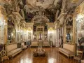 Złocone wnętrze pałacowe, przypominające muzeum w Madrycie, z malowidłami na suficie i bogatymi zdobieniami.