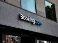 Logo Booking.com na szarym, kamiennym budynku. Planujesz podróż i szukasz najlepszych ofert? Z booking cashback Twoje wakacje będą tańsze!