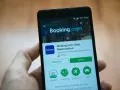 Telefon z aplikacją Booking.com. Użytkownik przegląda szczegóły, być może w celu zgłoszenia booking reklamacja.