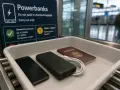 Na tacy do kontroli bezpieczeństwa leżą telefon, powerbank i paszport. Tablica informuje o limicie powerbanków Ryanair.