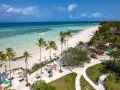 Rajska plaża na Zanzibarze, z turkusową wodą i palmami. Nawet podczas pory deszczowej Zanzibar zachwyca pięknem.