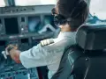 Pilot samolotu w słuchawkach i okularach przeciwsłonecznych, siedzący w kokpicie.
