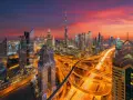 Wieczorny widok na Dubaj z drapaczami chmur i autostradą. W tle widać Burdż Chalifa. To miasto, gdzie kwitnie handel i **waluta Dubaju** jest symbolem rozwoju.
