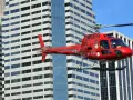 Czerwony helikopter Liberty przelatuje obok wieżowców. Zastanawiasz się, ile kosztuje lot helikopterem nad Nowym Jorkiem?