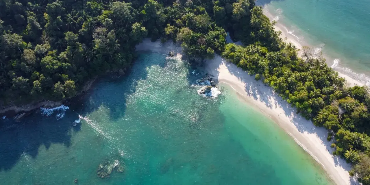 Rajska plaża na Kostaryce, idealne miejsce na wakacje. Turkusowa woda, biały piasek i bujna zieleń.