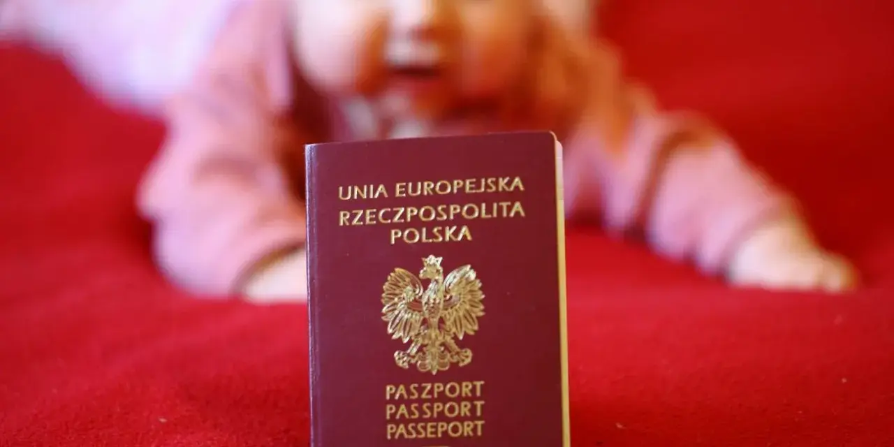 Paszport dla dziecka, gotowy na podróże po Europie. W tle rozmazana twarz malucha.