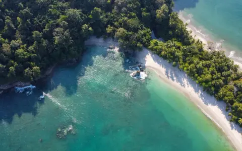 Rajska plaża na Kostaryce, idealne miejsce na wakacje. Turkusowa woda, biały piasek i bujna zieleń.