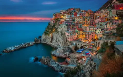 Kolorowe domy Cinque Terre, Włochy, w blasku zachodzącego słońca. Idealne miejsce na wycieczkę do Włoch.