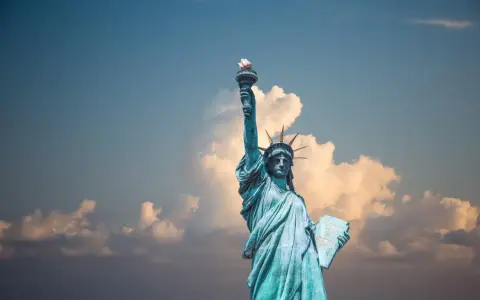 Statua Wolności z pochodnią w górze, symbol USA. Planujesz podróż? Pamiętaj o ubezpieczeniu turystycznym USA.