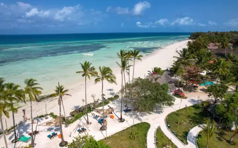 Rajska plaża na Zanzibarze, z turkusową wodą i palmami. Nawet podczas pory deszczowej Zanzibar zachwyca pięknem.