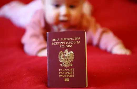 Paszport dla dziecka, gotowy na podróże po Europie. W tle rozmazana twarz malucha.
