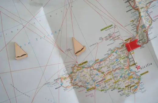 Planujesz podróż na **Sycylię**? Mapa pokazuje główne **lotniska** i trasy, a żaglówki sugerują morską przygodę.