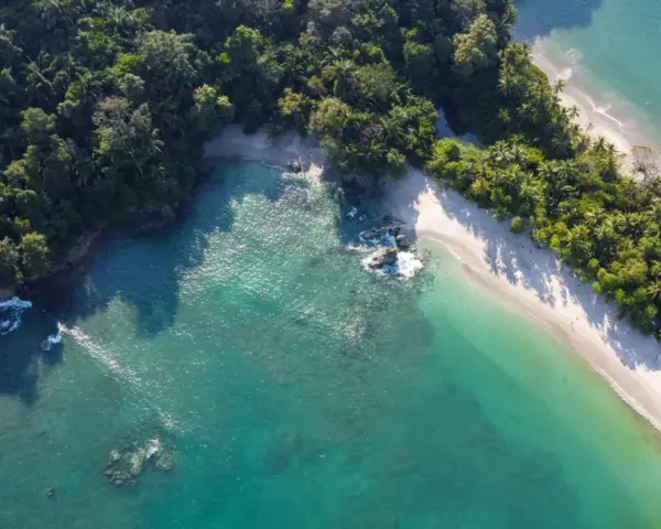 Rajska plaża na Kostaryce, idealne miejsce na wakacje. Turkusowa woda, biały piasek i bujna zieleń.
