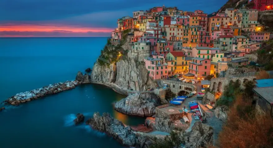 Kolorowe domy Cinque Terre, Włochy, w blasku zachodzącego słońca. Idealne miejsce na wycieczkę do Włoch.