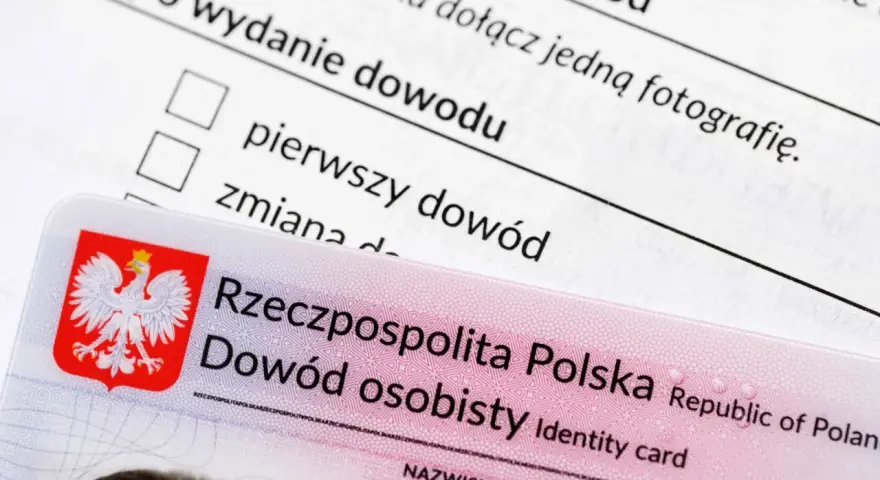 Nowy dowód osobisty leży na formularzu wniosku. Widoczny jest orzeł w koronie i napis "Rzeczpospolita Polska".