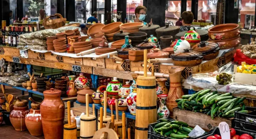 Stoisko z ceramiką, butelkami wina i świeżymi warzywami. Idealne miejsce, by zastanowić się, co przywieźć z Albanii – gliniane naczynia, lokalne produkty czy rękodzieło.