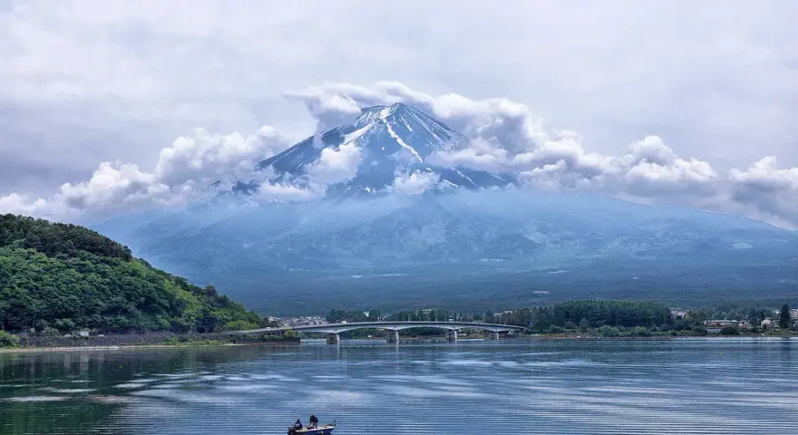 Majestatyczny Fudżi wyłania się z chmur nad jeziorem. Zastanawiasz się, ile się leci do Japonii, by zobaczyć ten widok?
