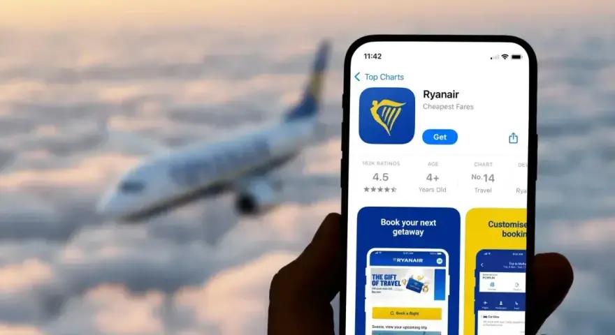 Ręka trzyma smartfon z aplikacją Ryanair, gotową do odprawy online. W tle widać samolot lecący wśród chmur.