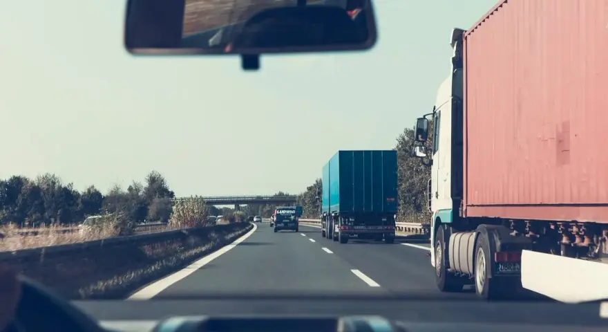 Jadąc autostradą, zastanawiam się, jakie kraje obejmuje zielona karta ubezpieczenia. W lusterku widzę inne ciężarówki.