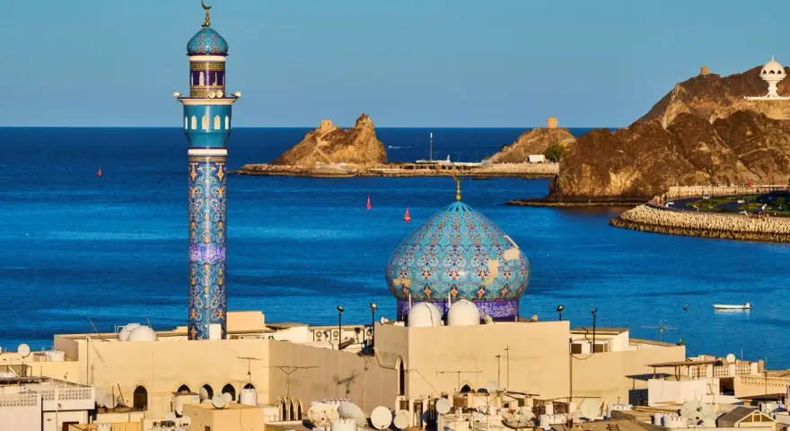 Błękitny minaret i kopuła meczetu nad Zatoką Omańską. Zastanawiasz się, ile się leci do Omanu?