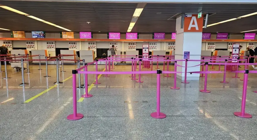 Puste stanowiska Wizzair, gdzie trwa odprawa. Różowe taśmy wyznaczają kolejkę do lotu.