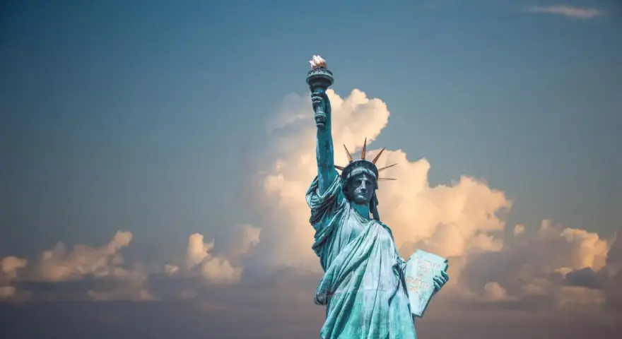 Statua Wolności z pochodnią w górze, symbol USA. Planujesz podróż? Pamiętaj o ubezpieczeniu turystycznym USA.