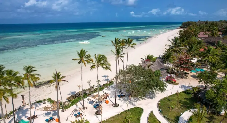 Rajska plaża na Zanzibarze, z turkusową wodą i palmami. Nawet podczas pory deszczowej Zanzibar zachwyca pięknem.