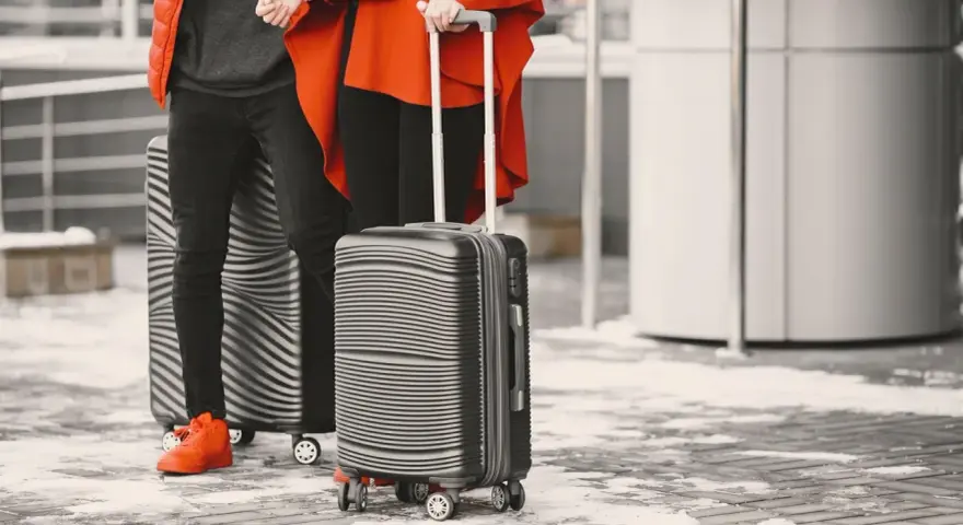 Para podróżnych z walizkami, idealnymi jako easyjet bagaż podręczny, gotowi na zimową podróż.