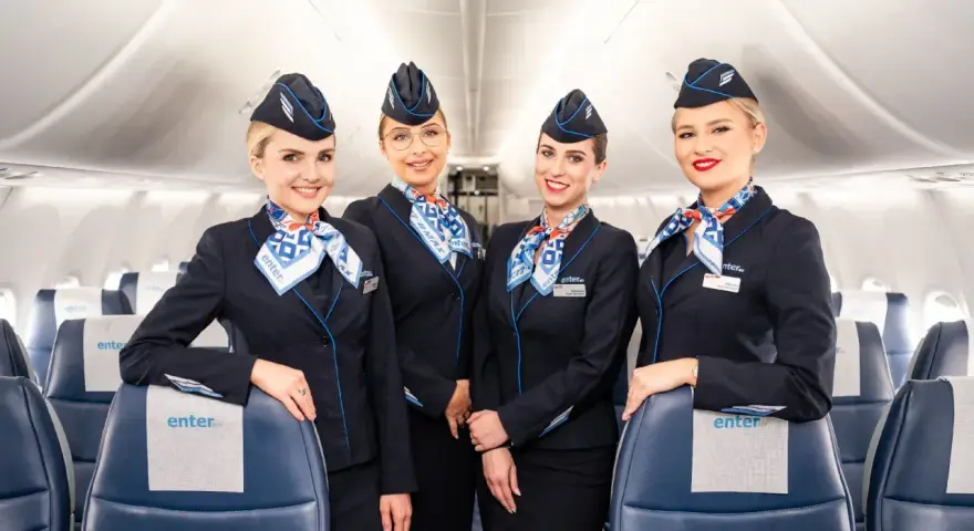 Uśmiechnięte stewardessy Enter Air w granatowych mundurkach. Opinie forum o Enter Air często chwalą miłą obsługę.