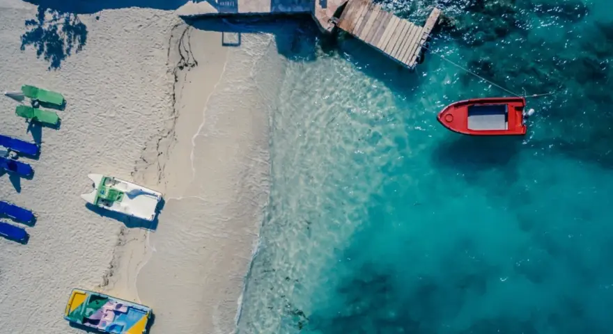 Idealne miejsce, gdzie w styczniu na wakacje: pusta plaża z łódkami i turkusowa woda.