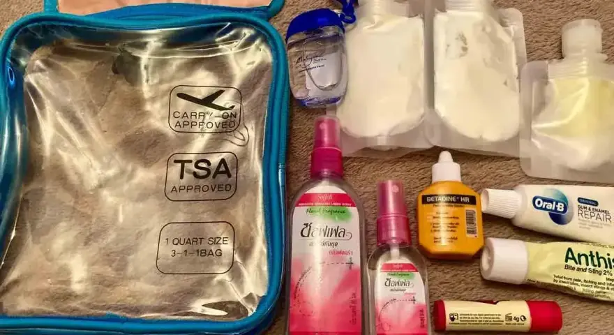 Przezroczysta kosmetyczka z oznaczeniem TSA Approved i płynami. Czy można przewozić dezodorant w bagażu rejestrowanym? Tak, w tym zestawie są małe pojemniki.